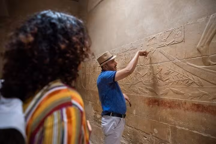 Tour guide explains carved reliefs inside the Grand Egyptian Museum on Cairo airport layover tour from CAI