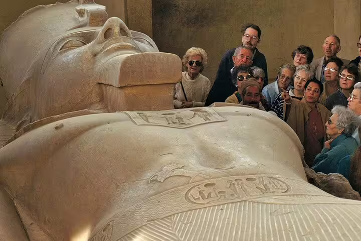 Tour group viewing the giant Ramses II statue in Memphis museum on Cairo layover pyramids tour