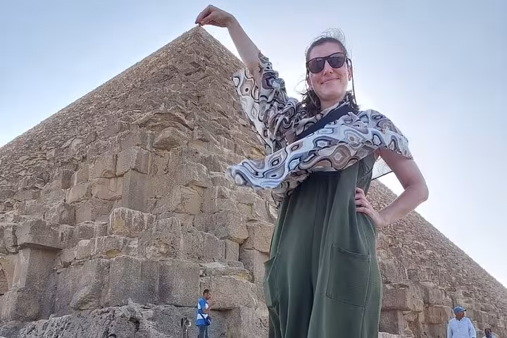 Traveler posing beside the Great Pyramid of Giza on a Cairo airport layover tour, Egypt stopover excursion