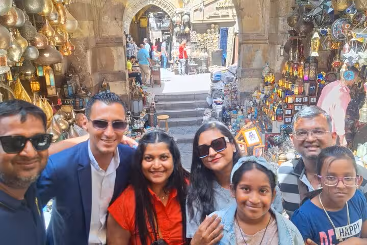 Tourists explore vibrant Cairo market, surrounded by colorful lanterns and local crafts on private 3-day pyramids tour.