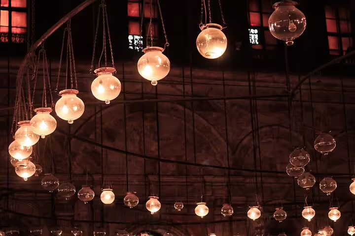 Hanging glass lantern lights inside a historic Cairo mosque, atmospheric stop on a 2-day Cairo short break tour