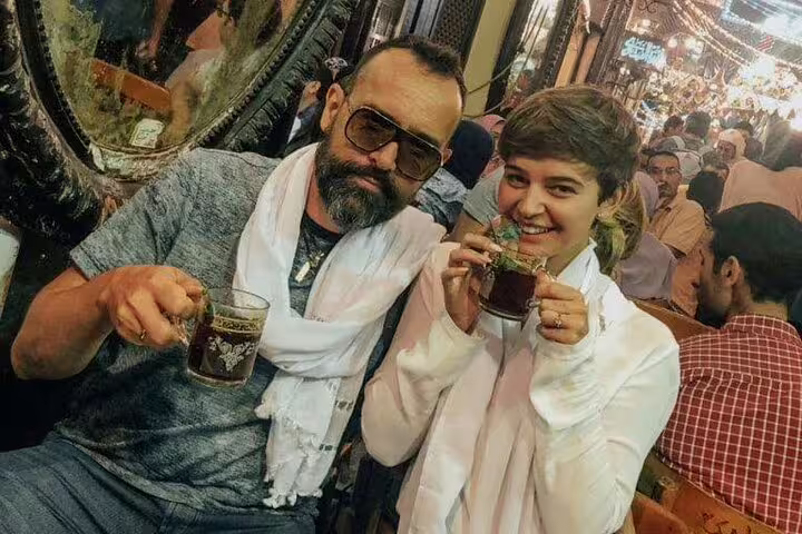 Tourists sip Egyptian tea at Al Fishawi Cafe during Cairo by night tour, near Al Moez Street in Old Cairo