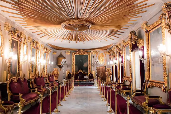 Ornate gilded hall with velvet seating, atmospheric Cairo by night tour experience before ElFishawy Cafe and dinner