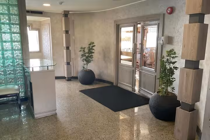 Cairo Nile dinner cruise boarding lounge with glass doors, polished floors, and potted plants