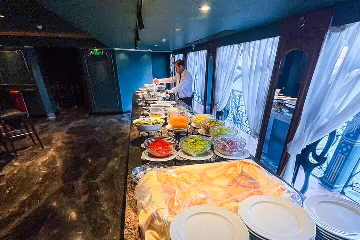 Buffet setup on Cairo Nile dinner cruise with fresh salads and chef service before belly dance and Tanoura show