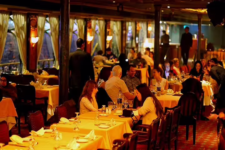 Elegant dining room on Cairo Nile dinner cruise with guests enjoying buffet dinner and warm evening ambiance