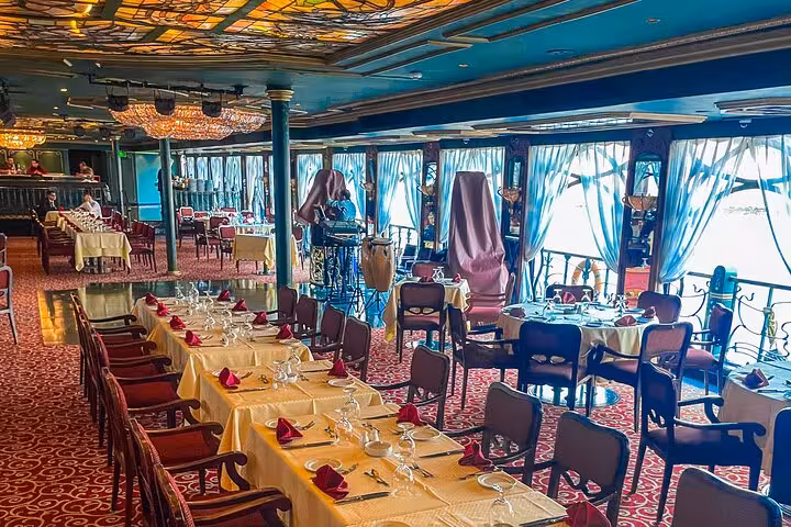 Cairo Nile dinner cruise restaurant deck with banquet tables, riverfront windows and evening ambiance