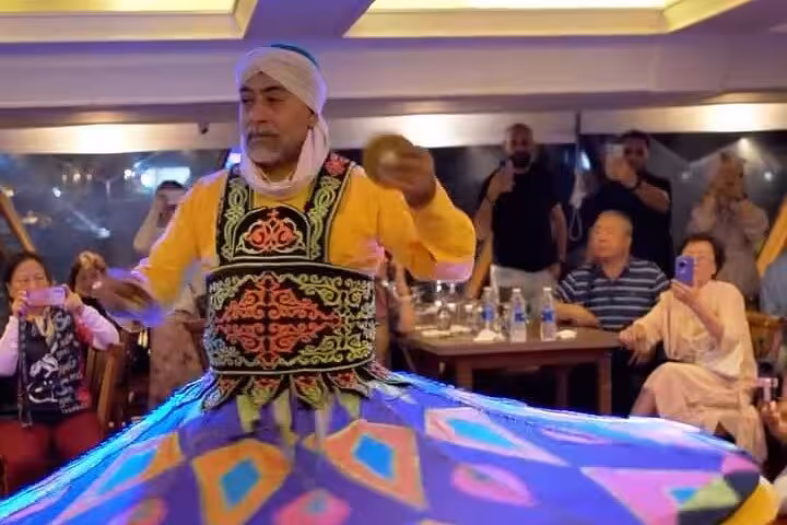 Tanoura whirling dervish show on Cairo Nile dinner cruise, colorful skirt spinning as guests watch