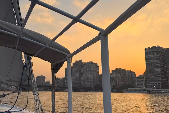 Cairo skyline at sunset seen from a relaxing Nile felucca ride, ideal for a peaceful sail with pickup