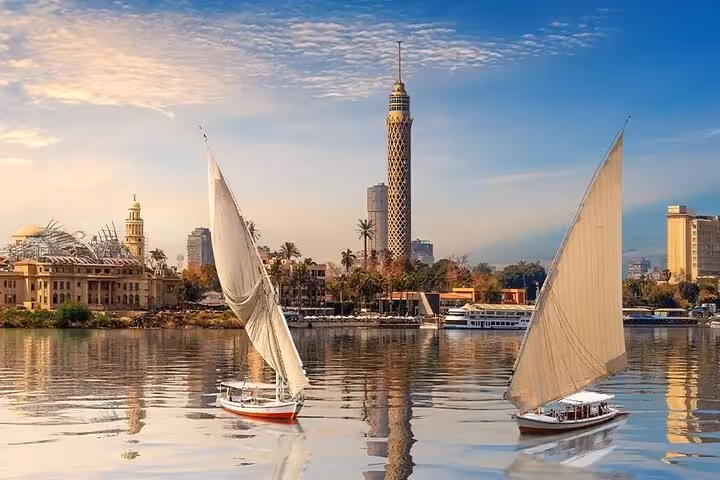 Nile River felucca sailboats with Cairo Tower skyline, scenic stop on Cairo bus tour from Sharm El Sheikh
