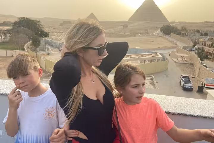 Family photo with the Great Pyramid of Giza behind, part of a Cairo private pyramids tour with Egyptian lunch