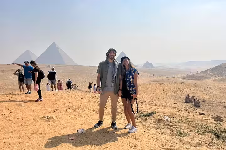 Couple posing at Pyramids of Giza viewpoint on Cairo private tour with guide and Egyptian lunch included