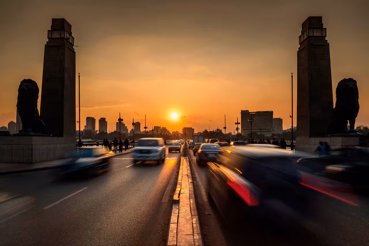Cairo city traffic at sunset on Qasr El Nil Bridge, ideal for private transfers and airport pickup