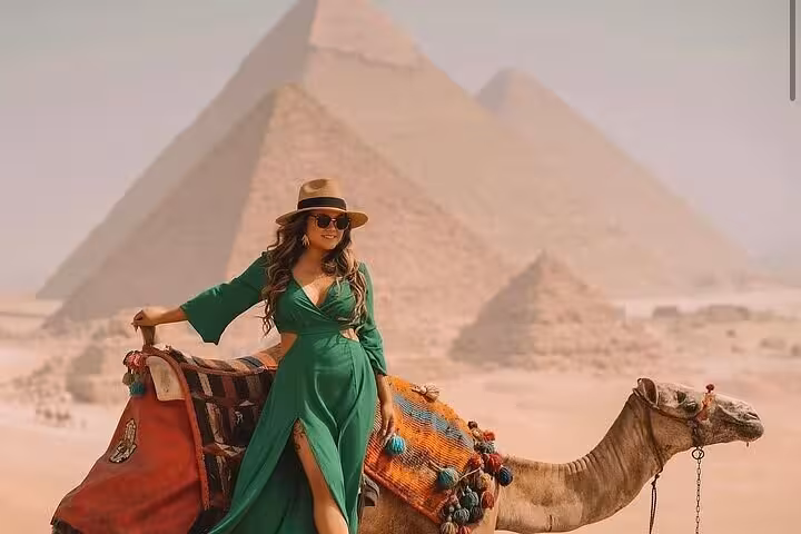 Traveler on camel with Giza Pyramids backdrop, Cairo day trip tour to Pyramids, Sakkara and Memphis