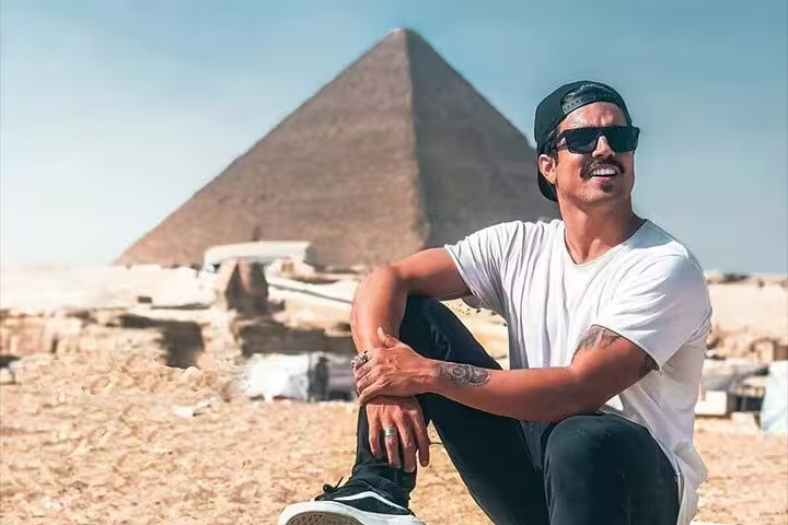 Traveler relaxing by the Great Pyramid of Giza on a 3-day Cairo short break tour package in Egypt