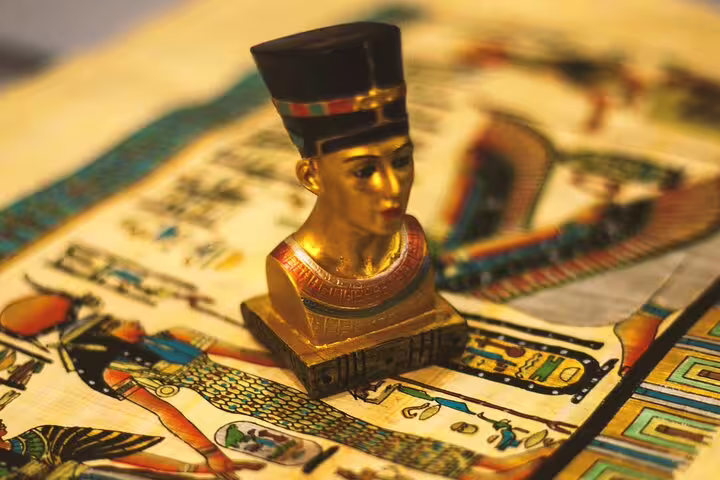 Golden pharaoh figurine on ancient papyrus art, showcasing Egyptian heritage on a 2-day Cairo short break package