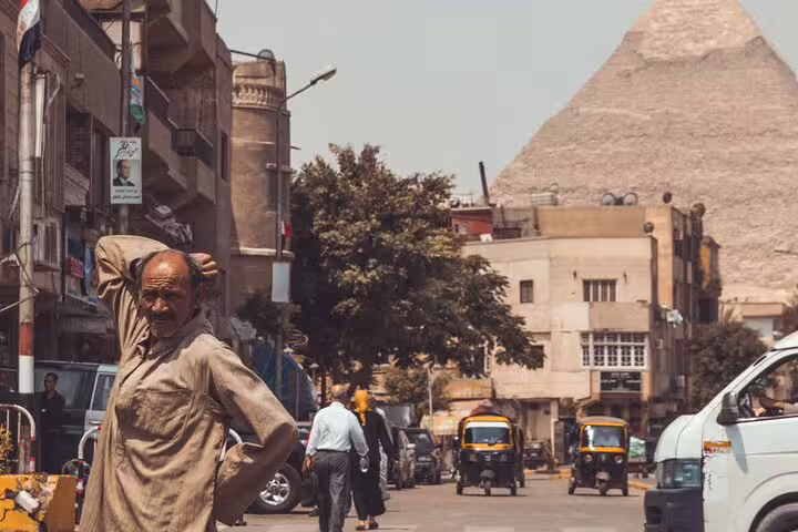 Cairo street scene with locals and traffic near the Giza Pyramids, part of a full-day Egypt sightseeing tour