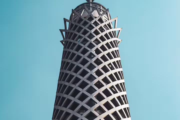 Close-up of Cairo Tower lattice design against blue sky, iconic stop on El-Moez Street and El-Fishawy Café tour