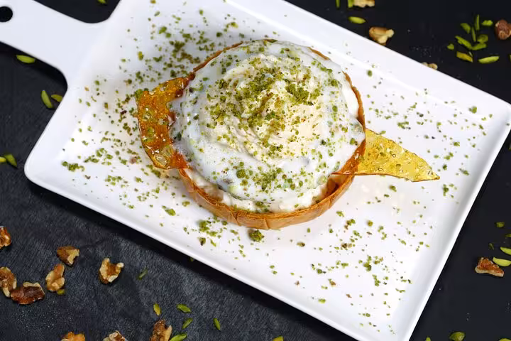 Indulge in Cairo's traditional dessert topped with creamy sauce and pistachios on the Authentic Cairo Food Tour.