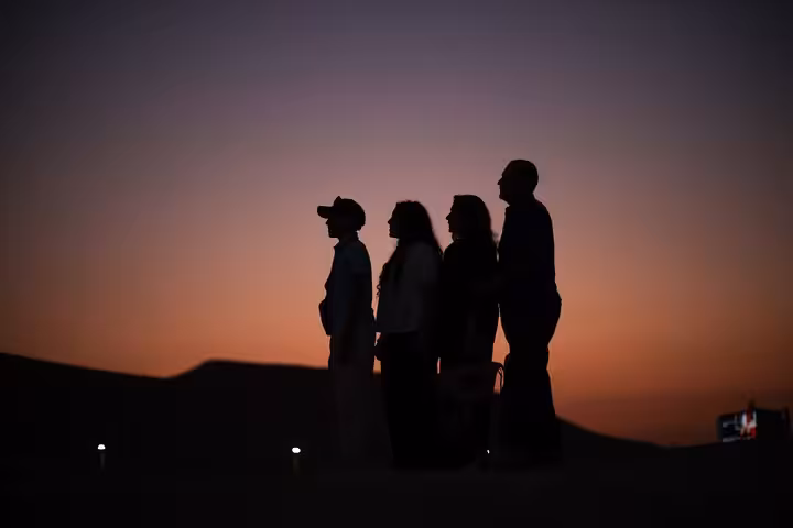 Guests silhouetted at sunset during VIP Arabian Night Bedouin dinner show in Giza with free photographer