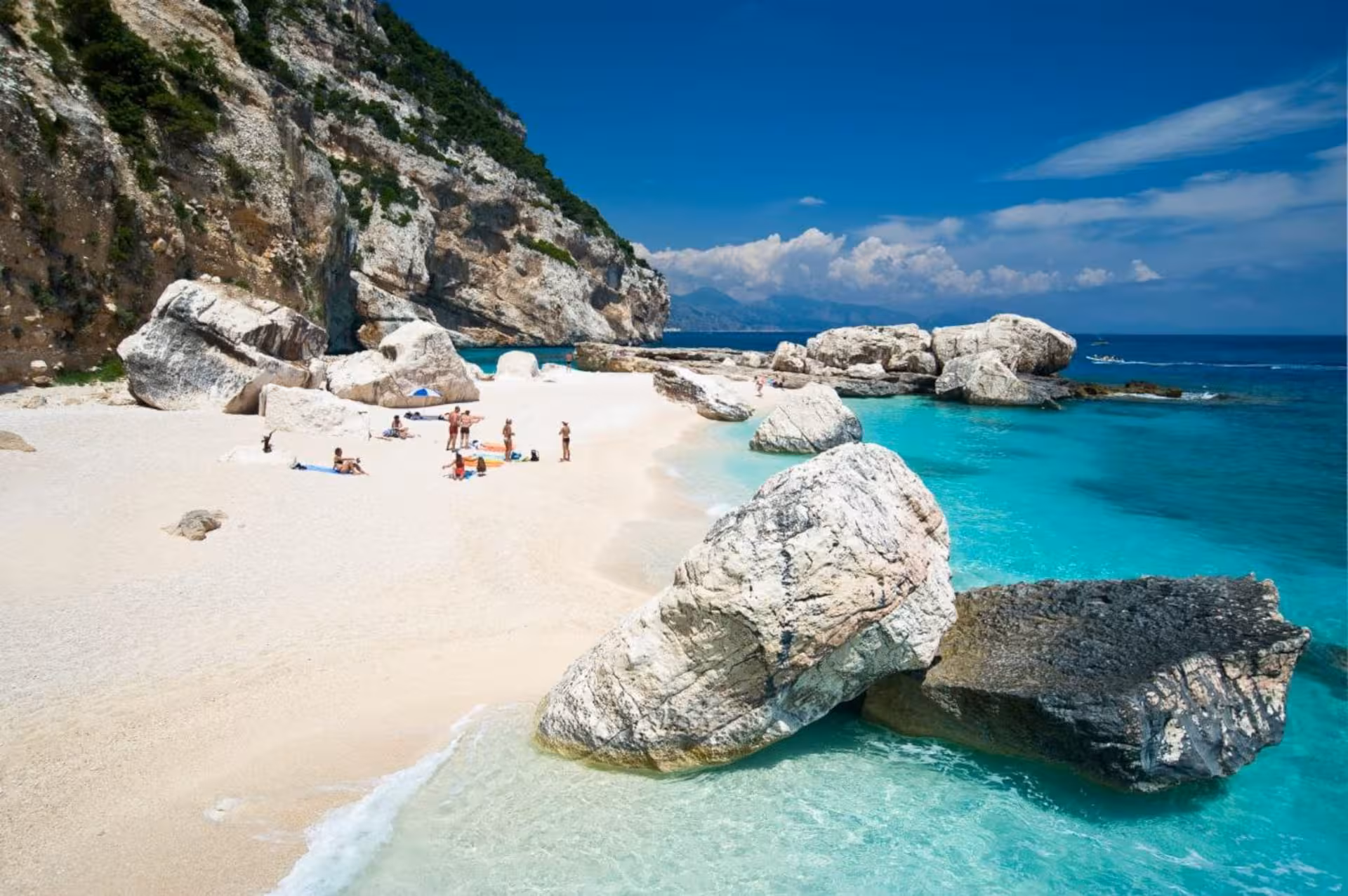 Cala Goloritzé's tranquil beach with large boulders and azure sea, a highlight of the Sardinia RIB adventure.
