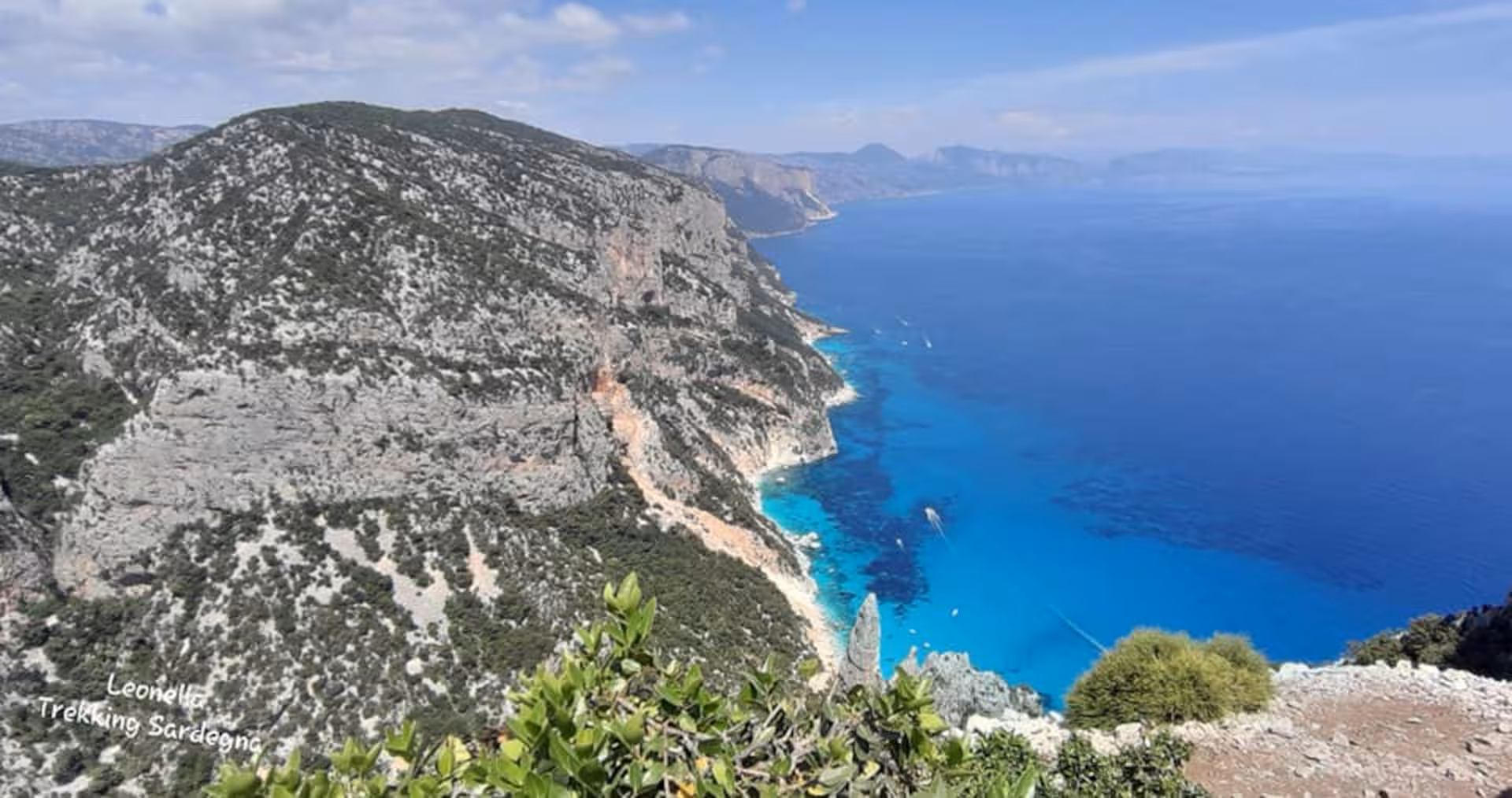 Stunning aerial view of Cala Goloritzè's rugged cliffs and turquoise waters, ideal for adventurous trekking tours.