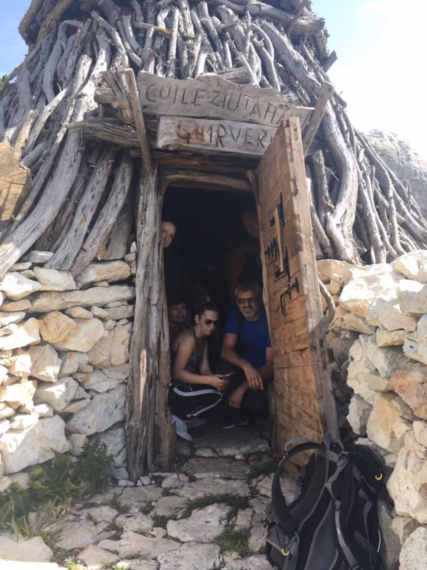 Visitors explore a traditional Supramonte shepherd's hut during a Jeep tour from Cala Gonone.