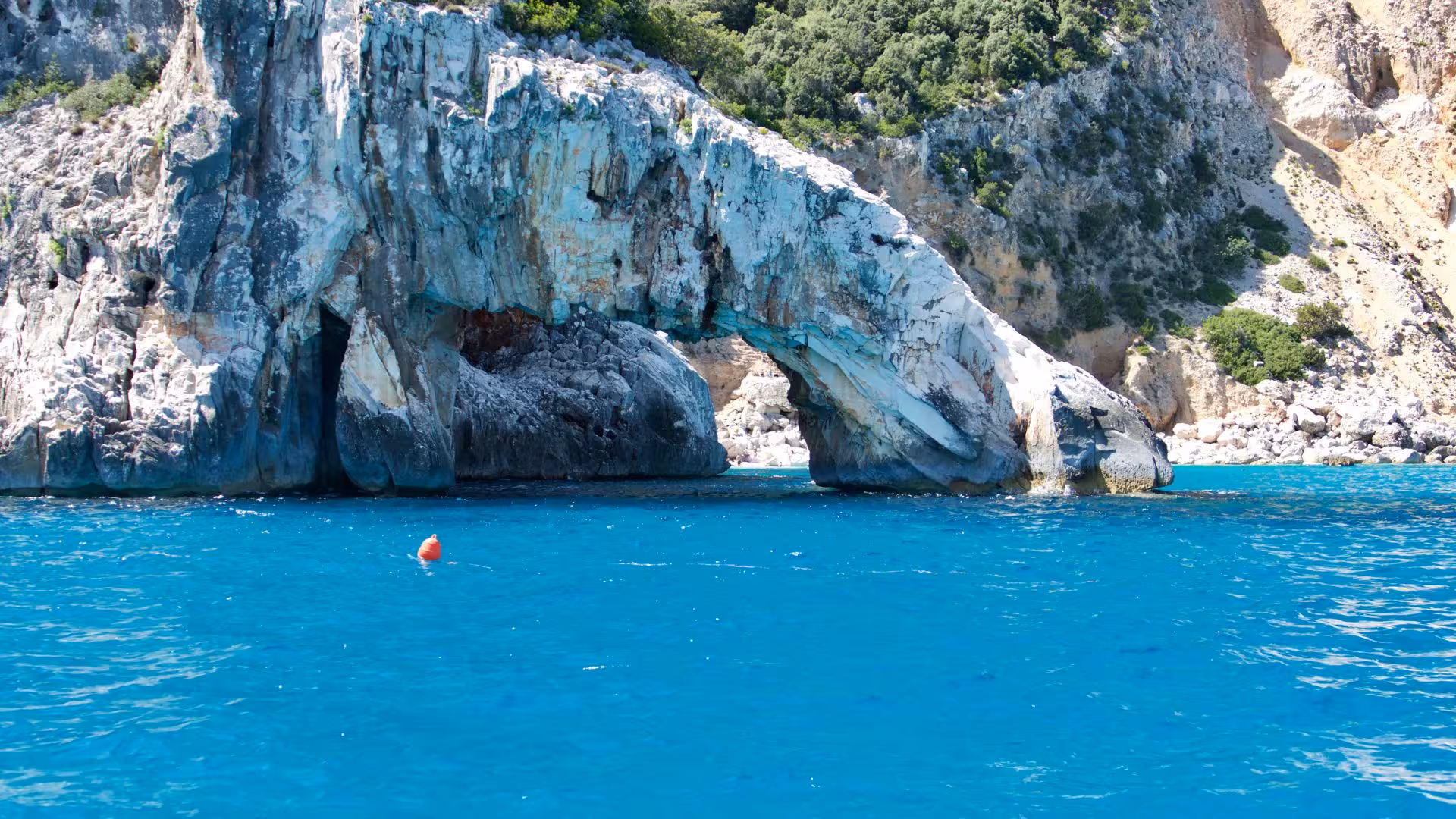Majestic rock arch over the blue sea at Cala Gonone, perfect for exploring by rented RIB boat.