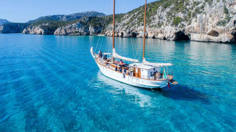 Scenic sailing boat tour in the Gulf of Orosei, showcasing crystal-clear waters and rugged coastline from Cala Gonone.