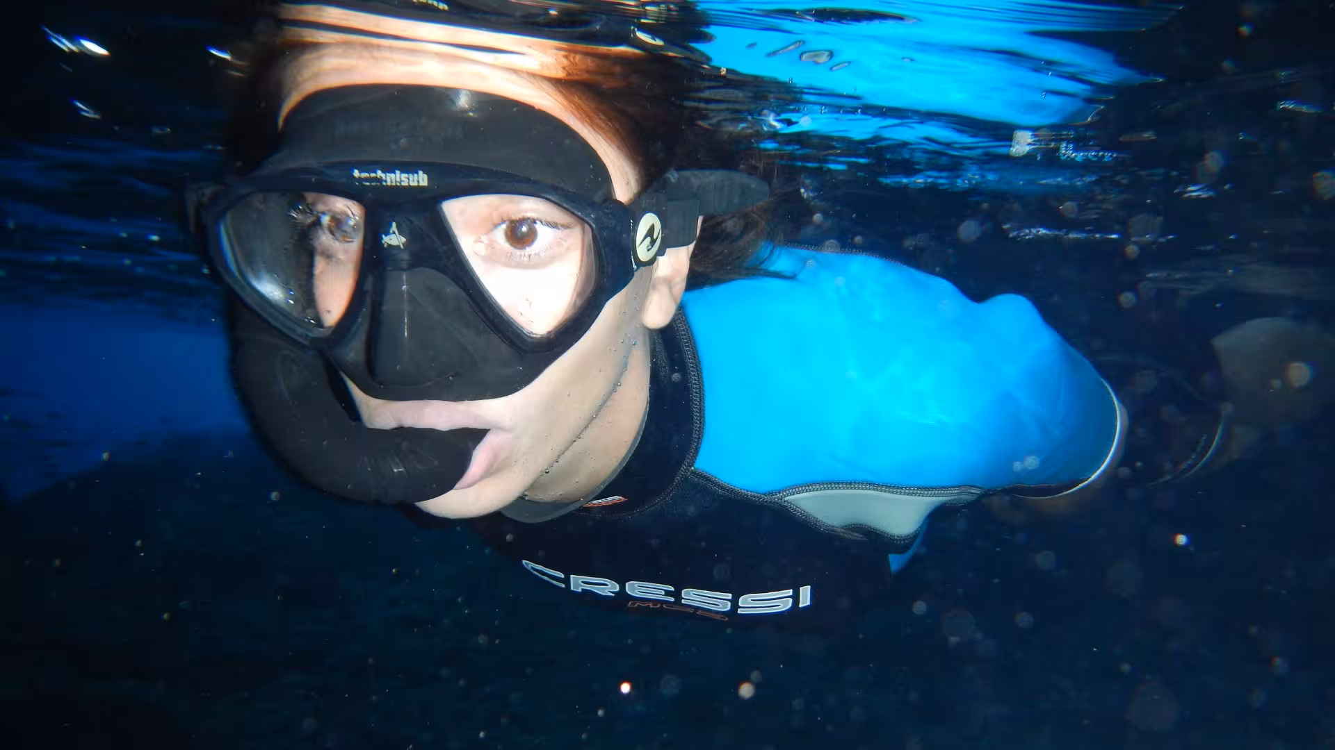 Close-up of a snorkeler in a wetsuit exploring Orosei Gulf's underwater scenery, part of a Cala Gonone snorkeling tour.