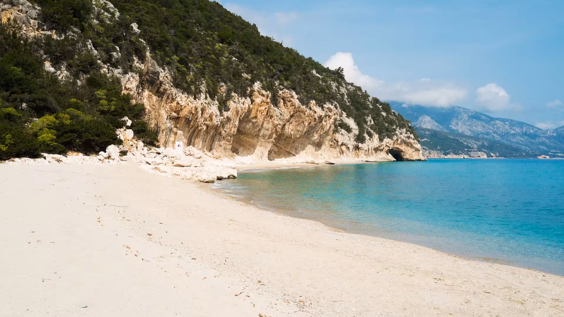 Scenic view of Cala Luna beach with turquoise waters and rocky cliffs, perfect for a boat tour from Cala Gonone.