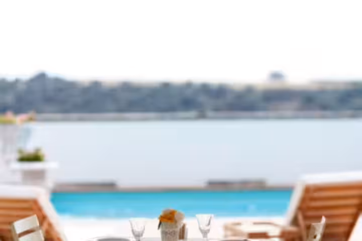 Elegant poolside dining setup with sun loungers and lake view at luxury Calabria castle hotel for a 3‑day VIP stay