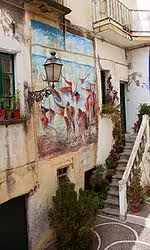 Colorful street mural and rustic stairway in an old Calabrian village, a charming stop on the 8 days self drive food tour