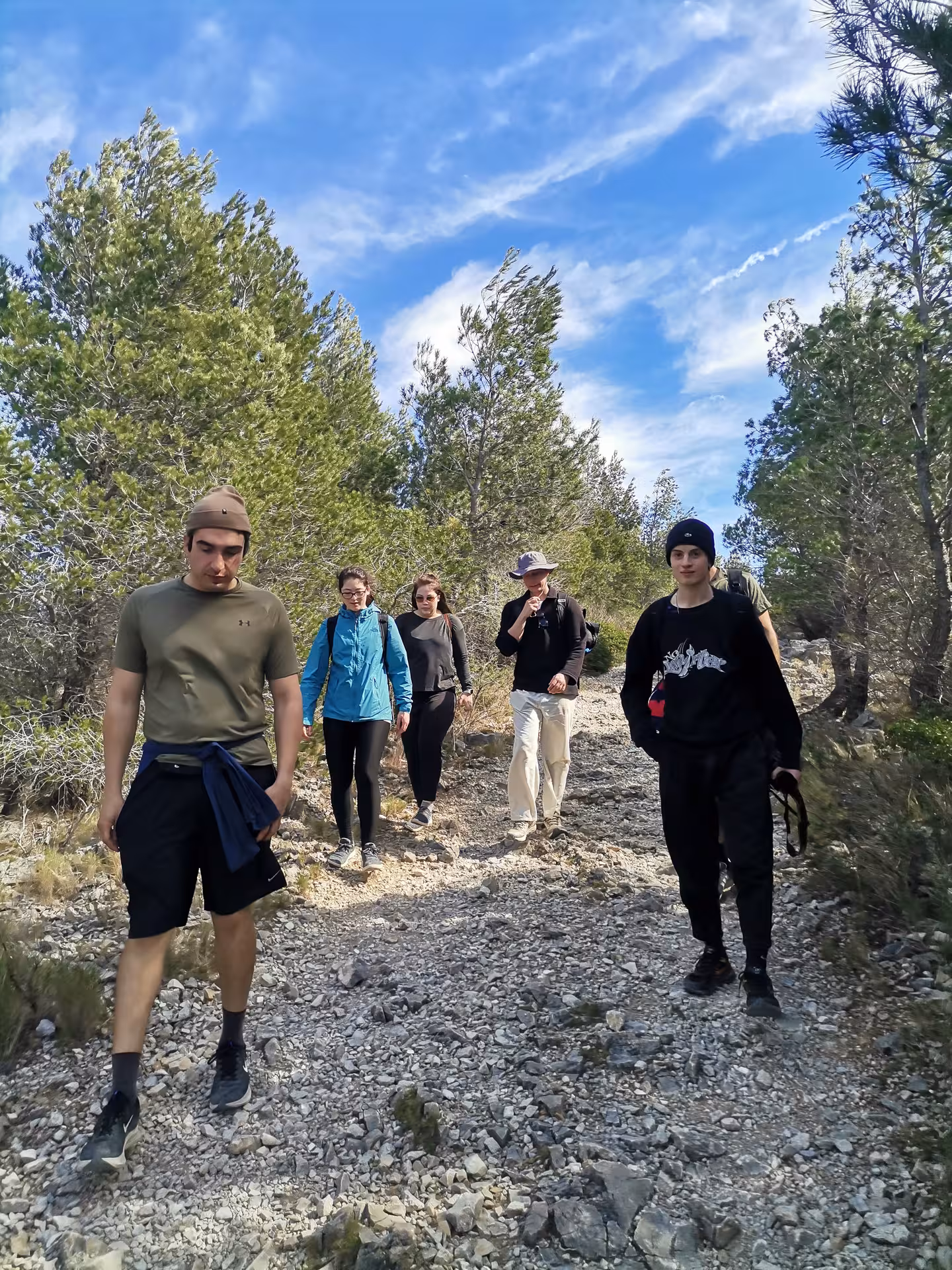 Guided Calanques hike with walkers on stony path through pines en route to Port-Pin, Port-Miou and En-Vau