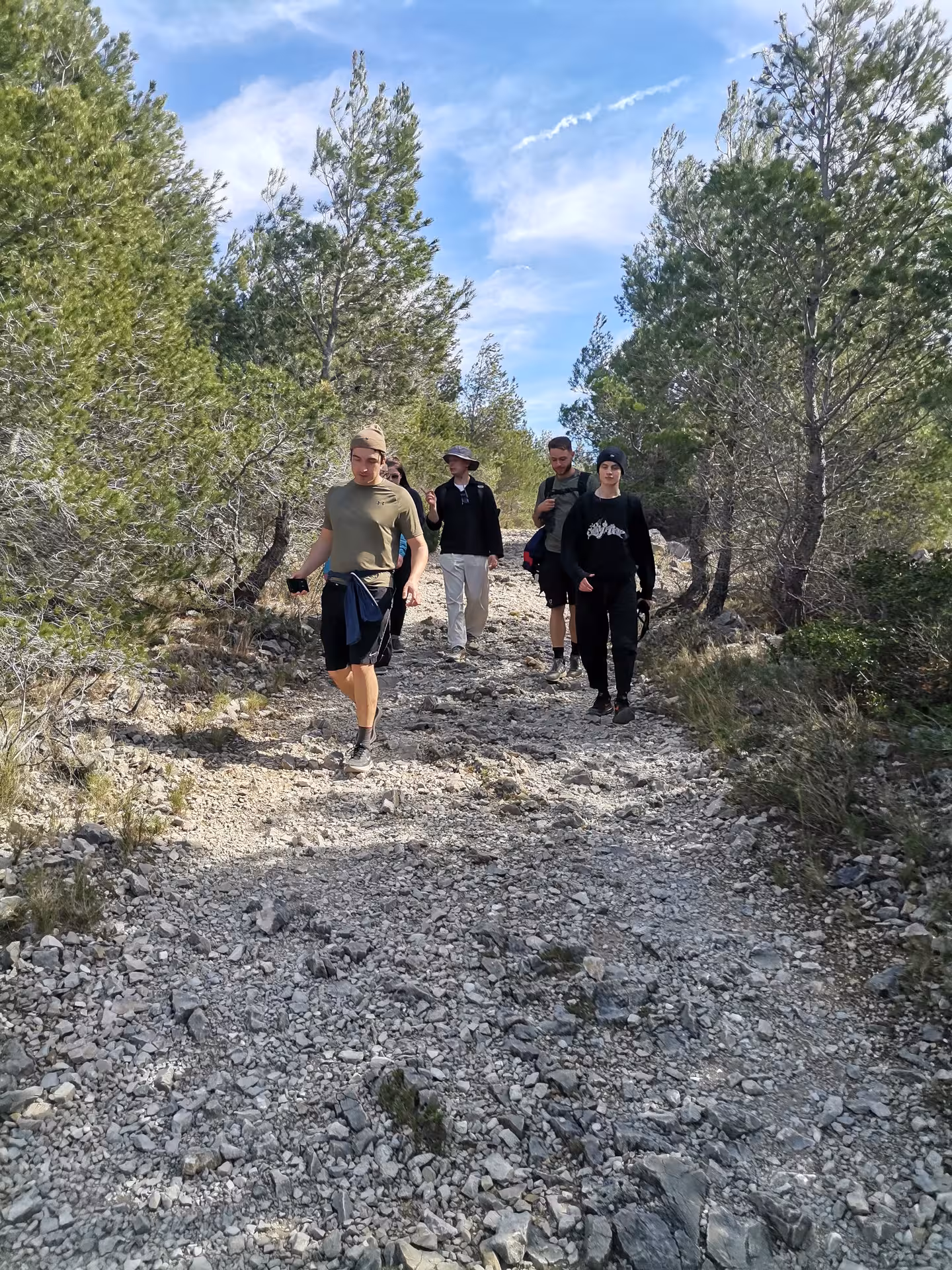 Small group hiking on rocky pine trail in Calanques National Park near En-Vau, Port-Pin and Port-Miou