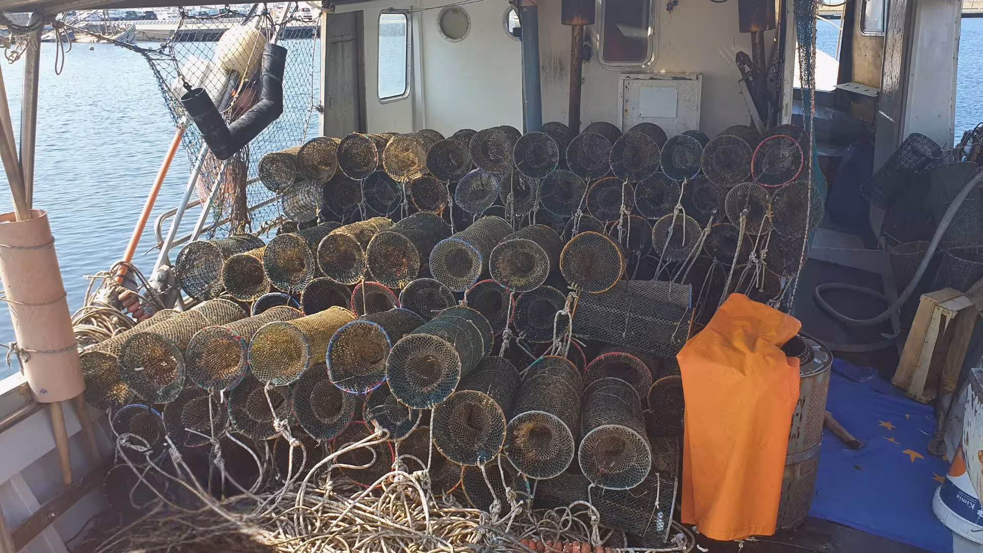 Fishing boat deck filled with lobster traps ready for Calasetta tour to San Pietro Island.