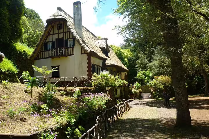 Charming cottage with thatched roof nestled in lush greenery, ideal for a peaceful getaway at Burned/Green Cauldron.