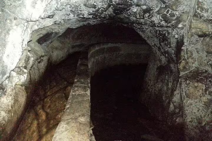 Explore the mysterious Burned / Green Cauldron cave with rugged stone walls and dimly lit passageways on this unique tour.