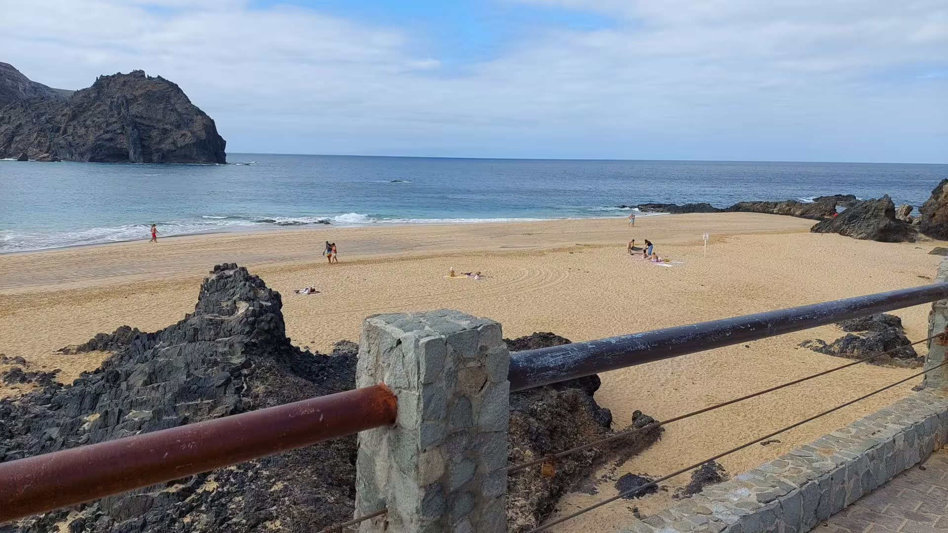 Scenic view of Calheta's southwest coastline with sandy beach, rocky cliffs, and azure ocean, ideal for a van tour adventure.