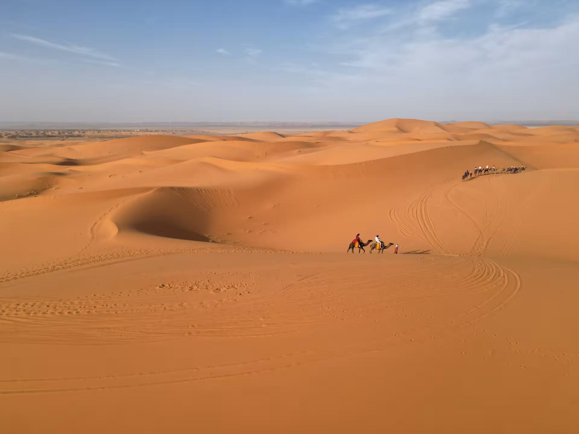Camel caravan traversing the vast dunes of the Sahara Desert near Merzouga, ideal for Fes to Marrakech tours.