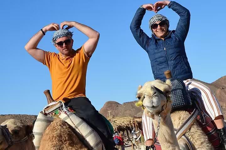 Tourists riding camels in Sharm El Sheikh desert, a fun add-on to sunrise or sunset ATV quad safari