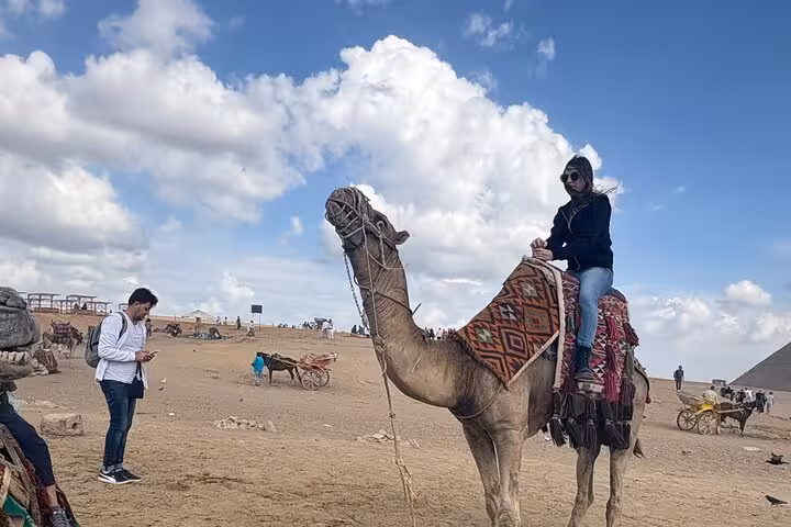 Traveler on a camel ride near the Giza Pyramids, Cairo desert adventure tour with panoramic views