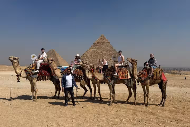 Camel ride at Giza Pyramids on a private Cairo tour, with panoramic view of Khafre pyramid behind