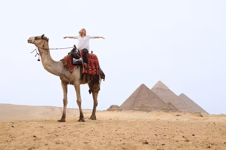 Camel ride at Giza Pyramids near Cairo on Hurghada tour, desert view with pyramids backdrop
