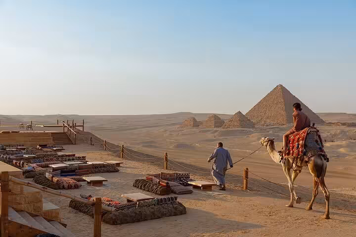 Camel ride viewpoint overlooking the Giza Pyramids at sunset, part of VIP Giza & GEM tour with Sphinx visit