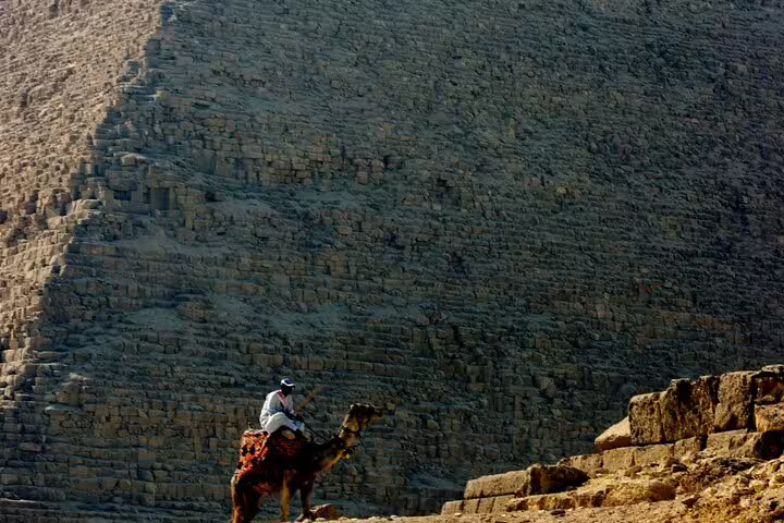 Camel rider at the base of the Great Pyramid of Giza on a private tour from Cairo with Egyptologist guide
