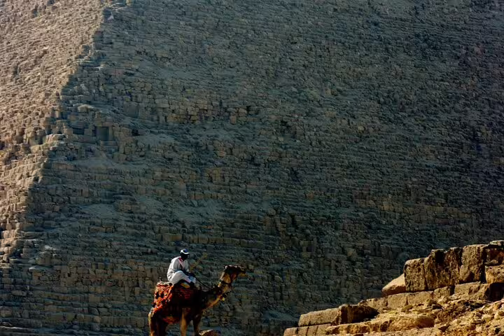 Camel rider in front of the Great Pyramid of Giza during a royal expedition tour of Giza, Saqqara and Dahshur