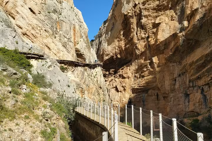 Scenic view of Caminito del Rey's winding boardwalk through steep limestone cliffs, perfect for adventure seekers.