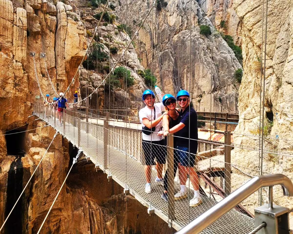 Happy hikers on Caminito del Rey suspension bridge in El Chorro gorge on a private guided walking tour
