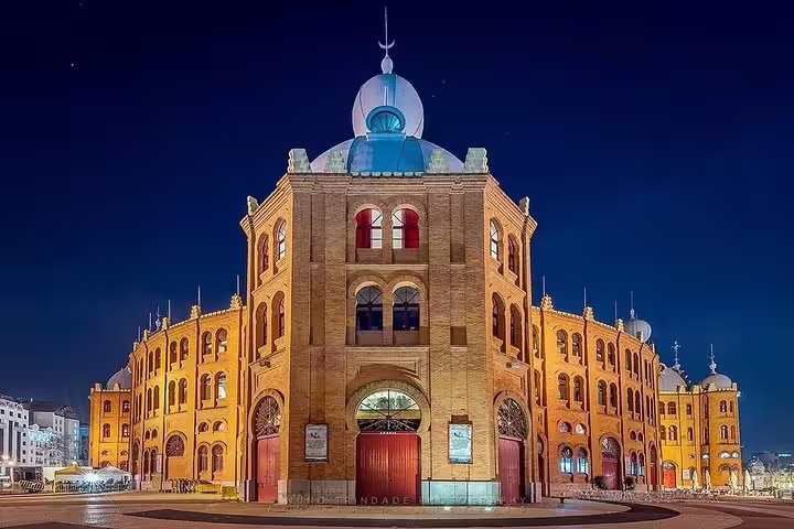 Night view of Campo Pequeno, an iconic neo-Moorish bullring in Lisbon, illuminated under a clear starry sky.